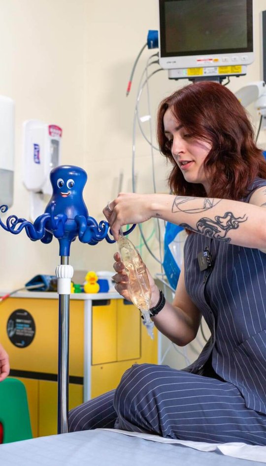 A Falmouth University student showing a healthcare professional her Octopus IV drip design 