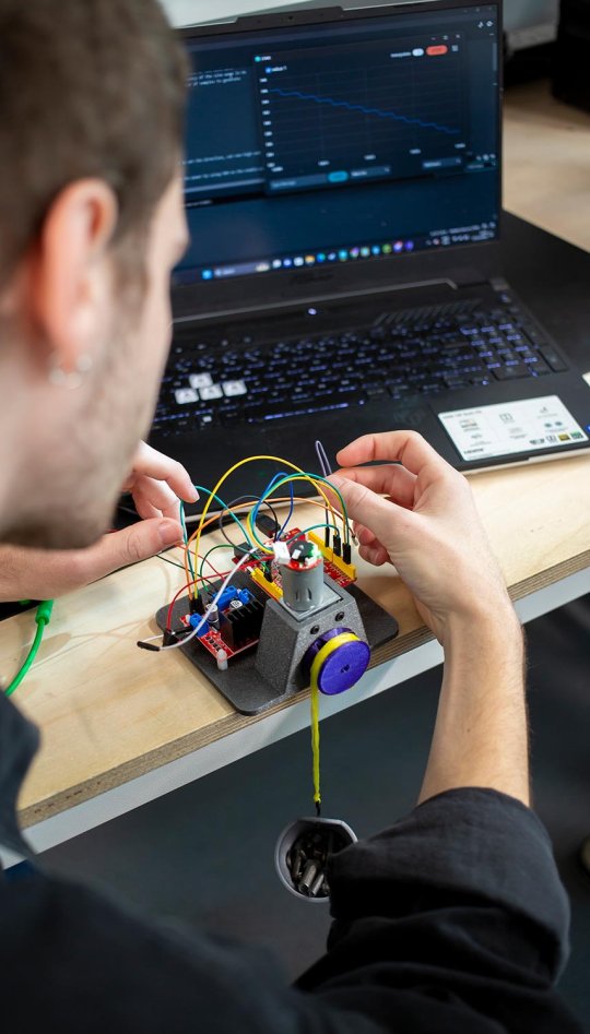 A male Robotics student handling cables