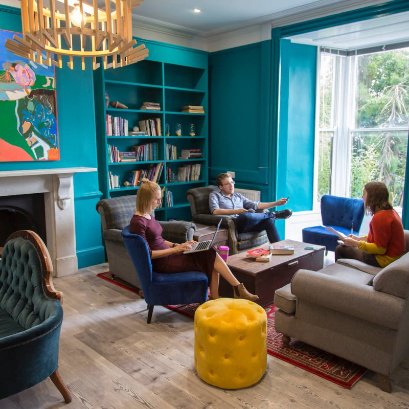 Students sat on sofas and discussing in the writers room.