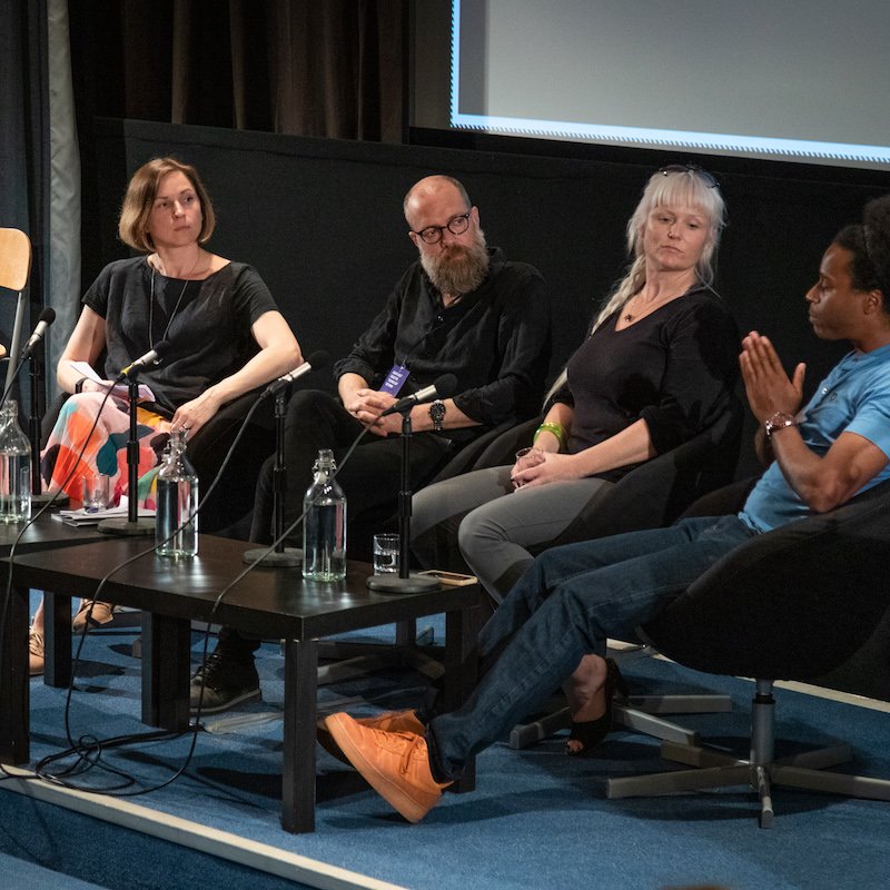 A panel of 4 people seated