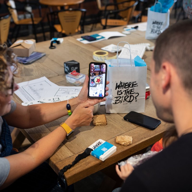 two people at a table looking at a phone