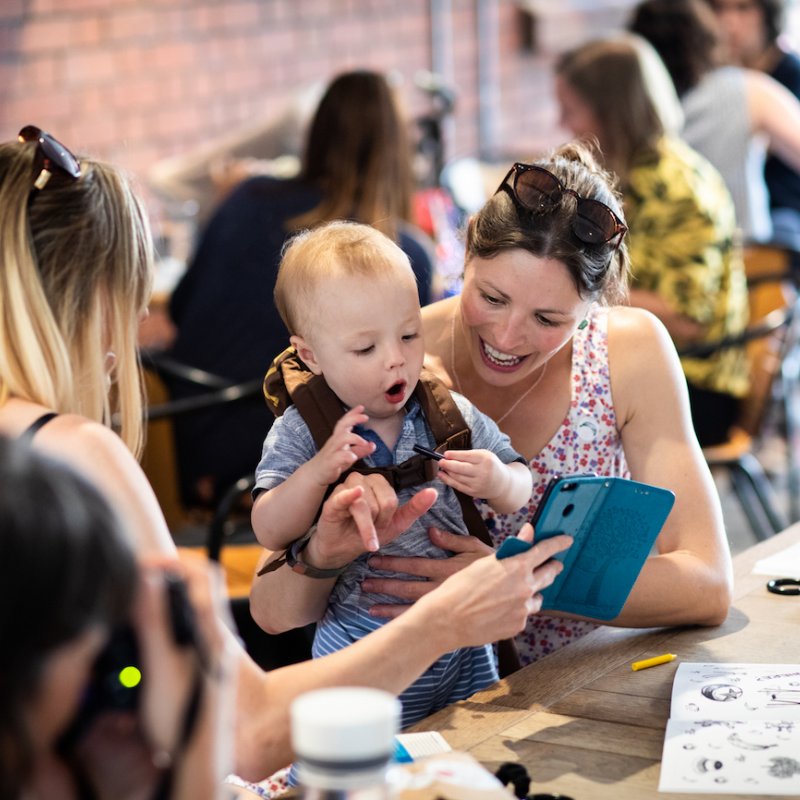 A woman and a toddler looking at a phone