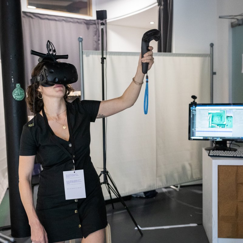 A woman in a black dress wearing a VR headset