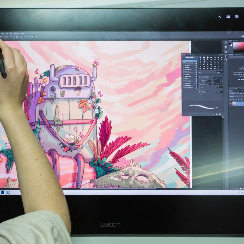 Animation student drawing a robot on a graphic tablet