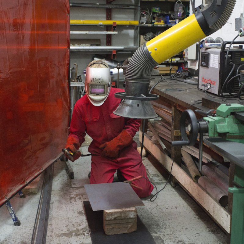 Falmouth student working in workshop with head mask on.