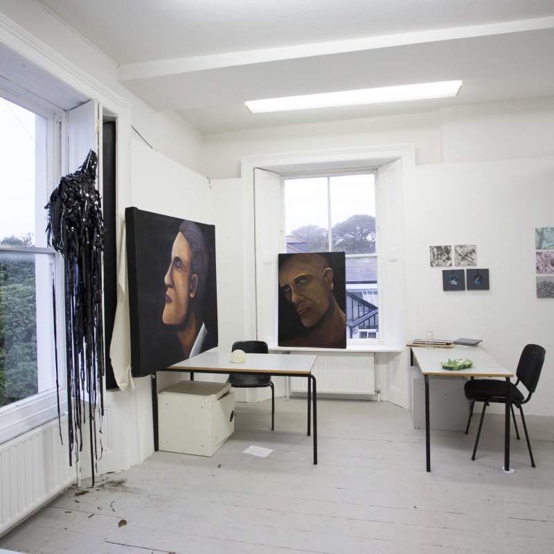 Art studio interior on Falmouth campus with two large painted portraits.