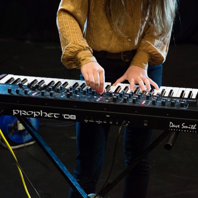 Female students hands playing keyboards and adjusting controls