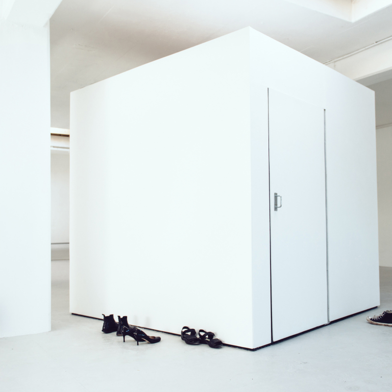 White cube room with shoes abandoned outside