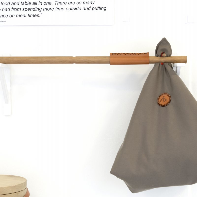 Folded picnic blanket on end of a carrying stick.