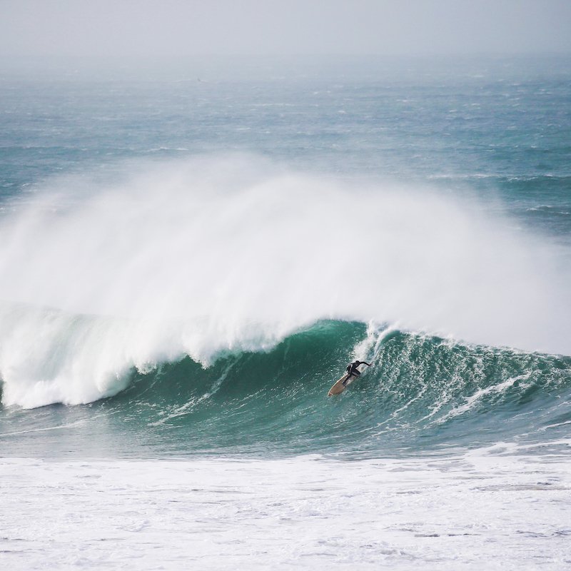 A surfer riding a large breaking wave