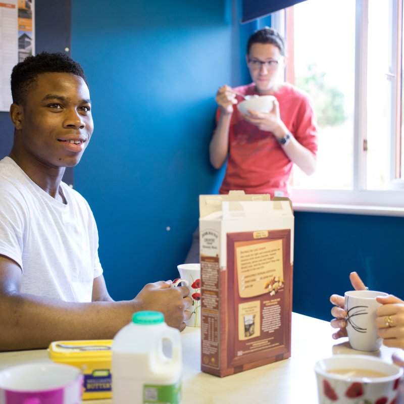 Students eating cereals in blue room.