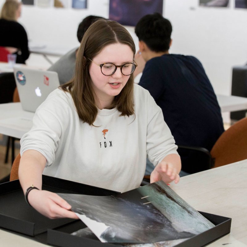Falmouth University student showing photography portfolio to lecturer.