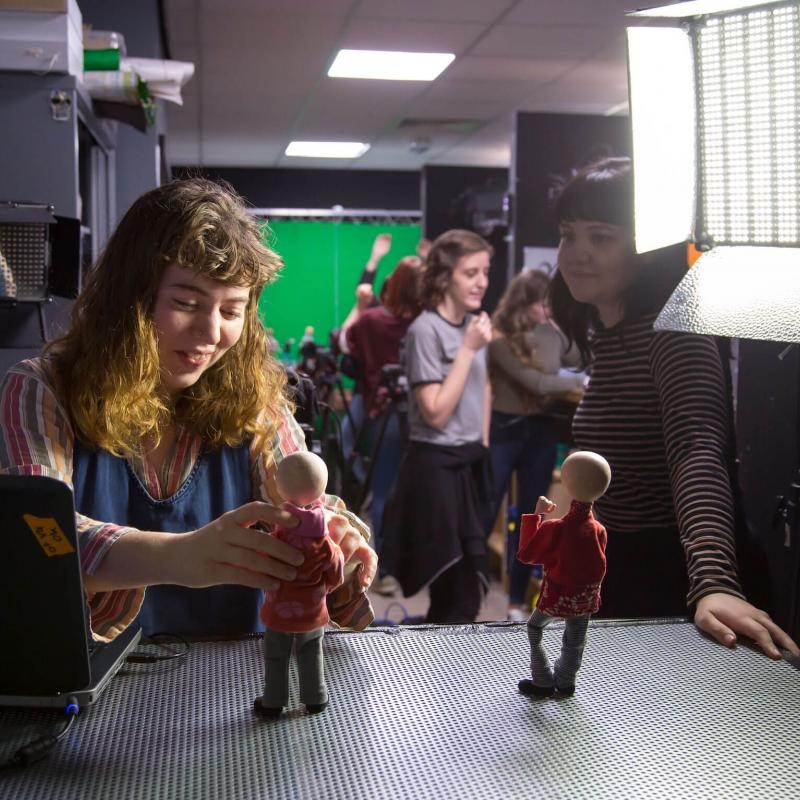 Animation student posing a model figure in a studio