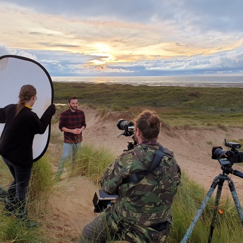 Students filming on beach