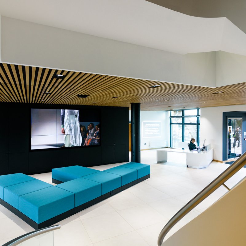 Stylish interior at the Creative Bridge with a blue sofa and digital screen