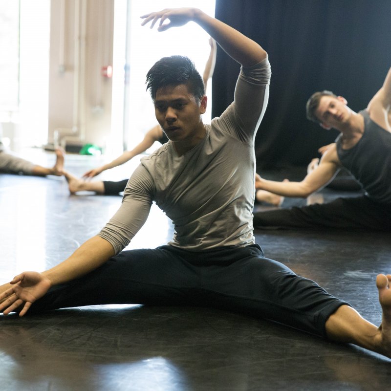 Male dancers stretching.