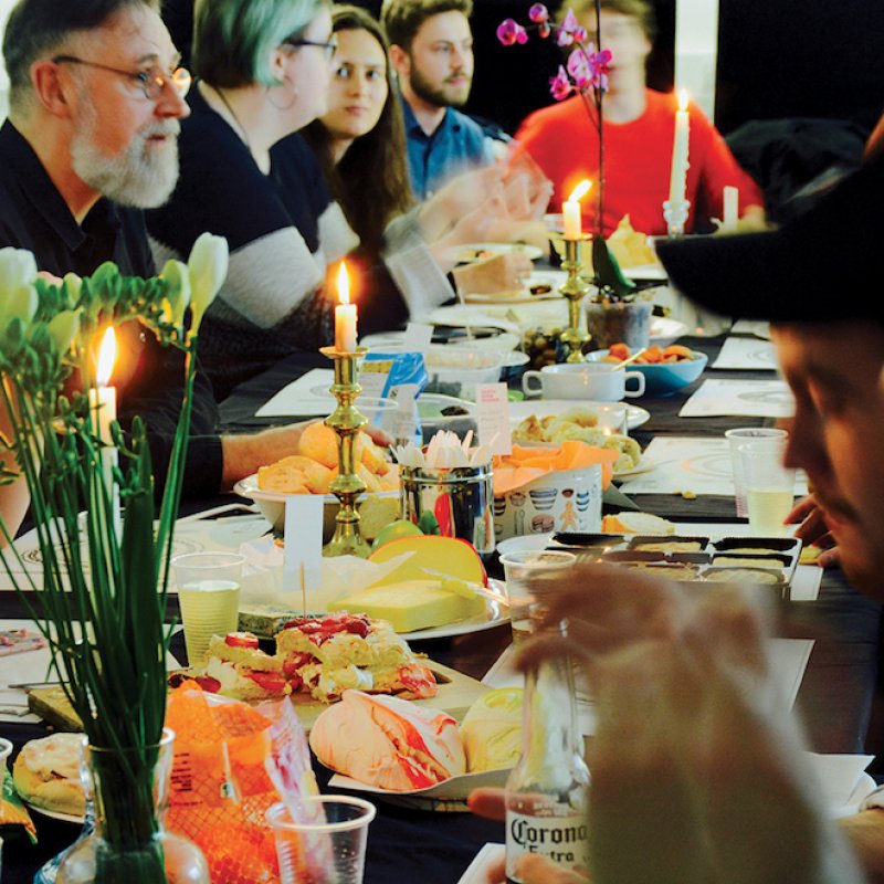 People sitting around a long table with candles