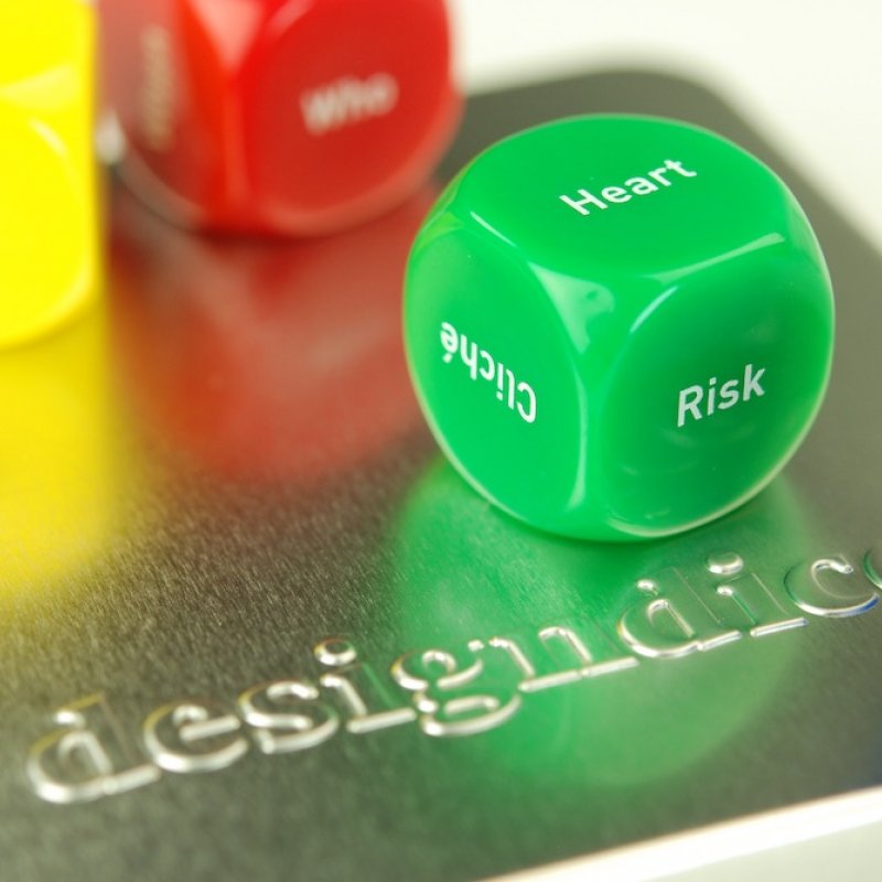 Yellow, red, green and blue dice on a metal tin surface