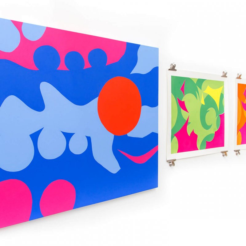 three colourful prints hanging on a white wall