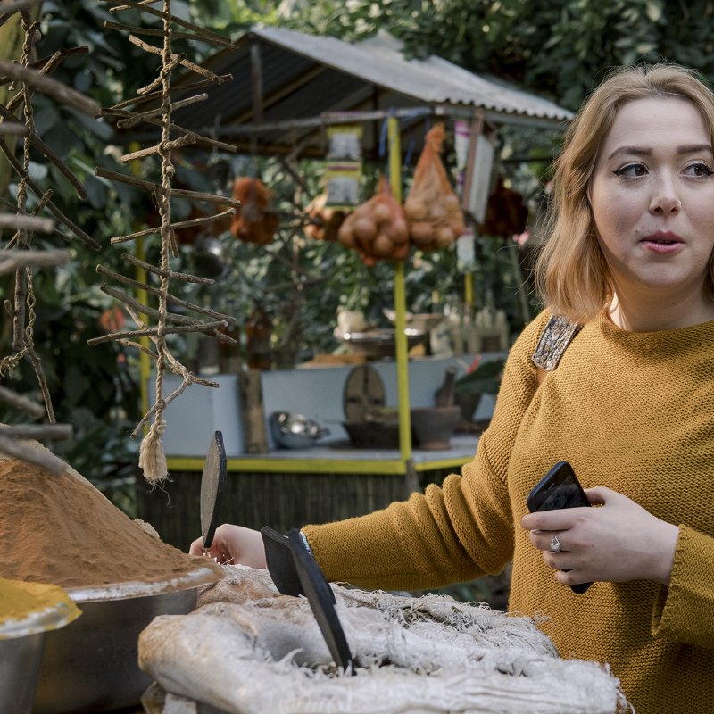 Girl stood in front of pile of spices at Eden.