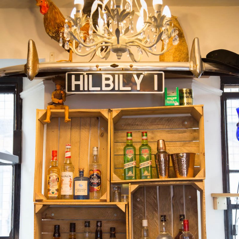 Shelves with bottles of alcohol and a number plate with Hilbily I