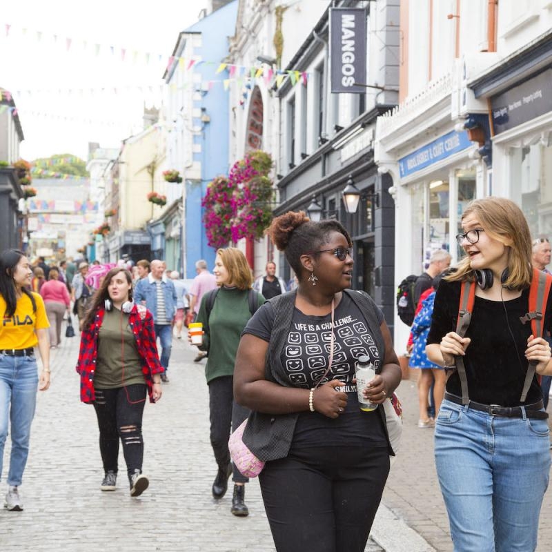 Group of students walking through Falmouth high street.