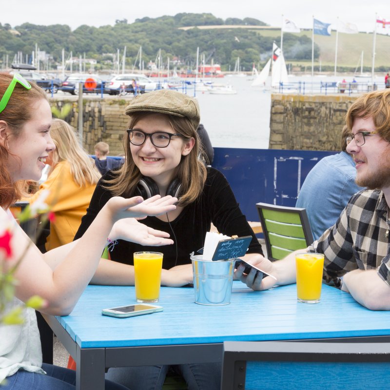 Students drinking orange juice at table