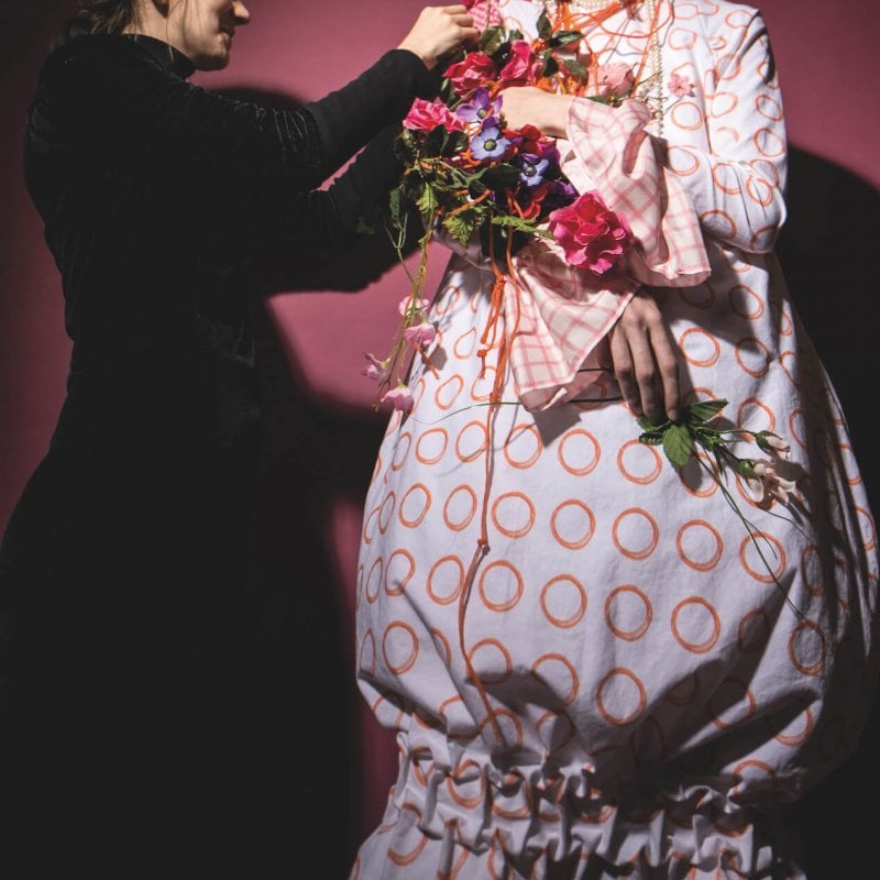 A Costume Design student styling a student wearing an oversized polkadot dress