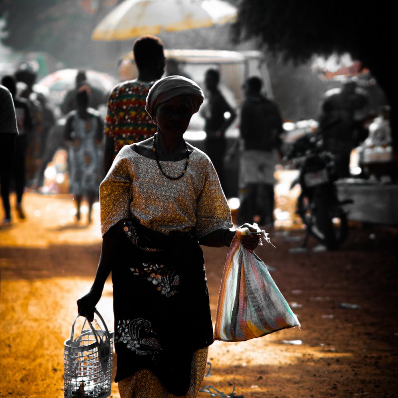 Woman in African dress carrying bags