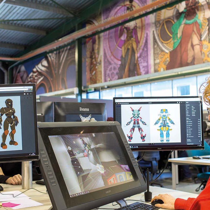 Student working on several screens in Falmouth University's Games Academy
