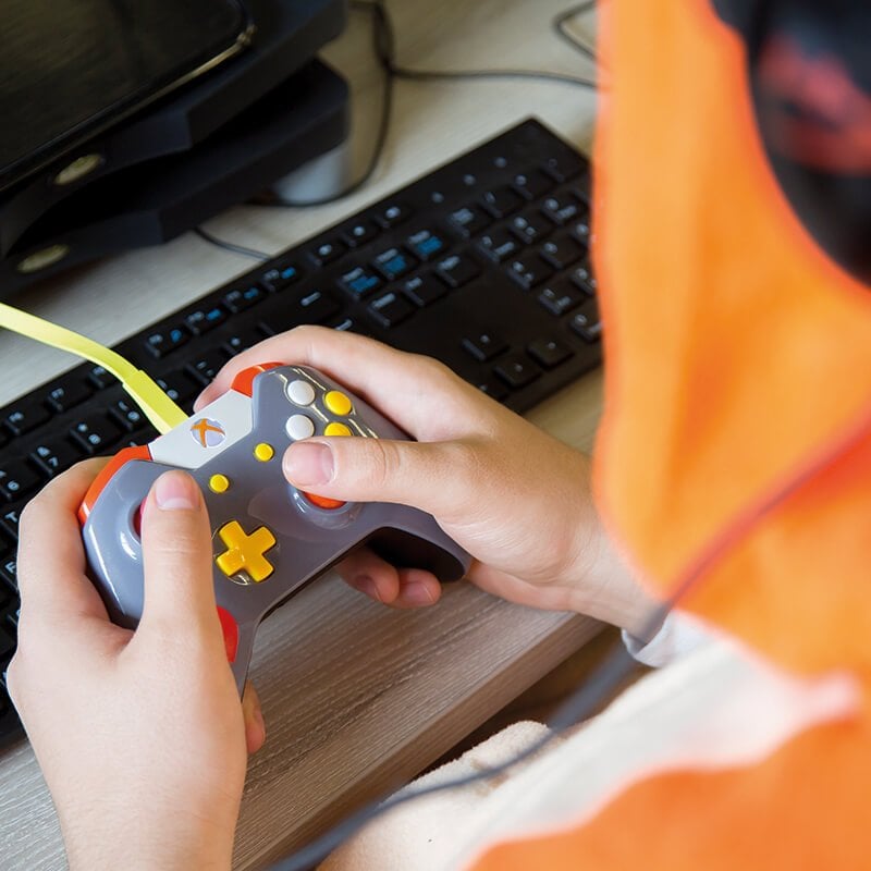 Close up of student hands on a games controller