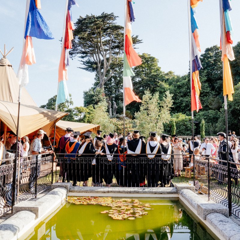 Guests gathered around a pond enjoying graduation 2019