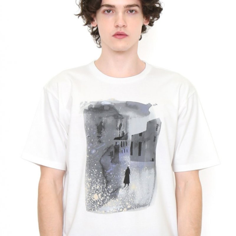 A boy wearing a white t shirt with a painting of a street at night