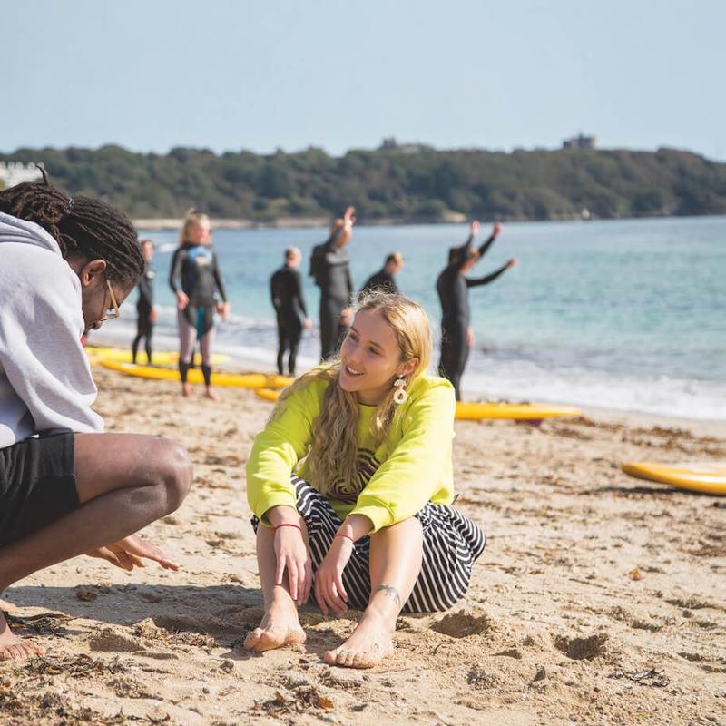 Two students talking on the beach in Falmouth