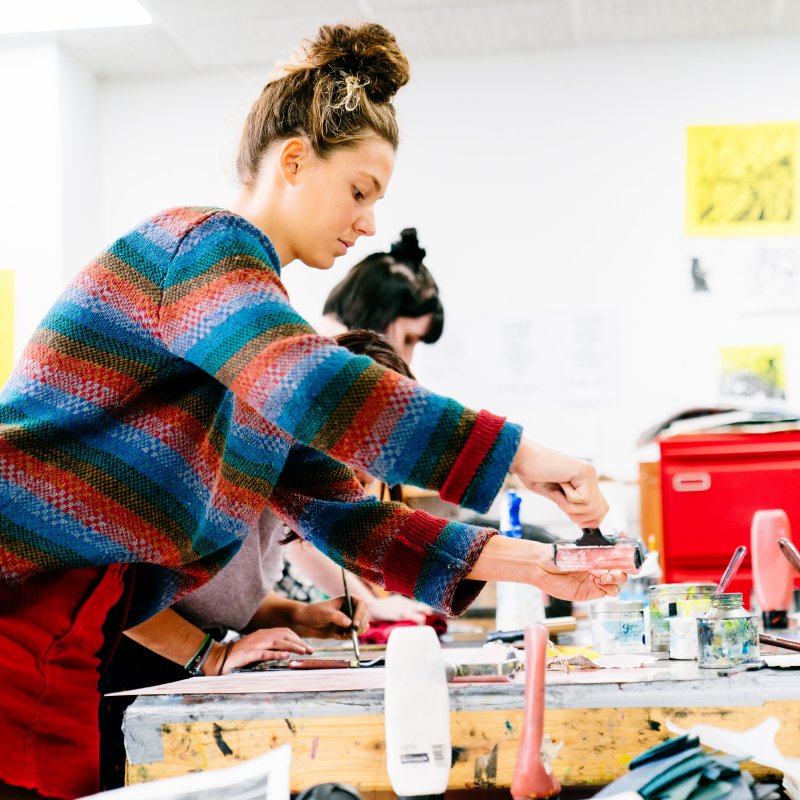 Female student wearing stripy jumper printing in studio