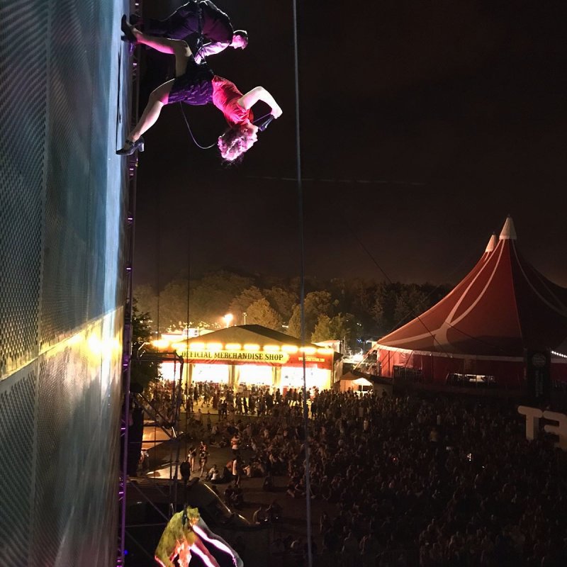 Dancers performing vertically up a wall attached by safety ropes