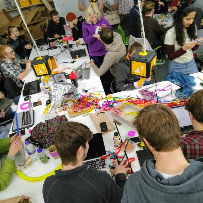 A group of Falmouth University students around a table with string and objects