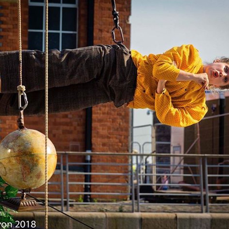 Dancer in a horizontal position held by a safety rope