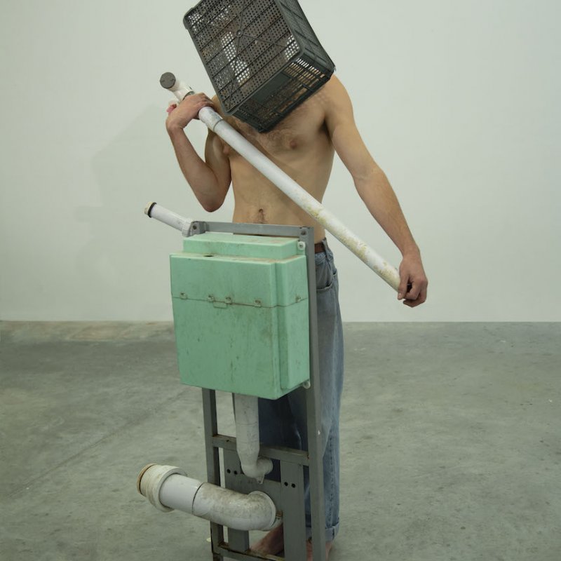 A man with a box over his head and holding a boiler