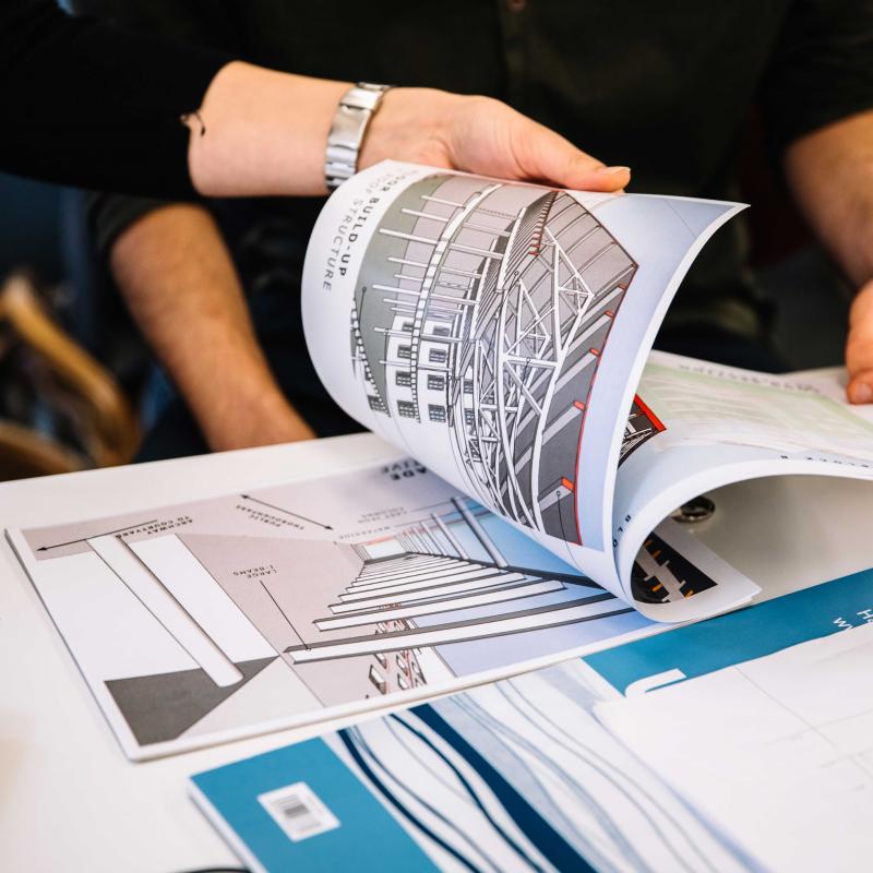 Hands turning pages of architecture book