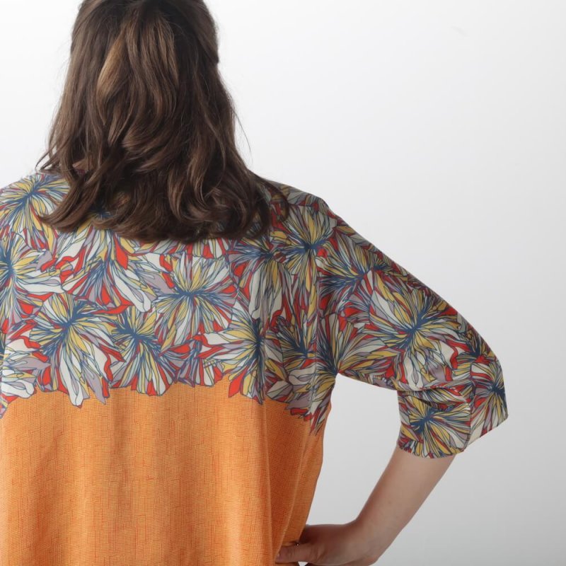 Model wearing jacket with digitally printed flower pattern.
