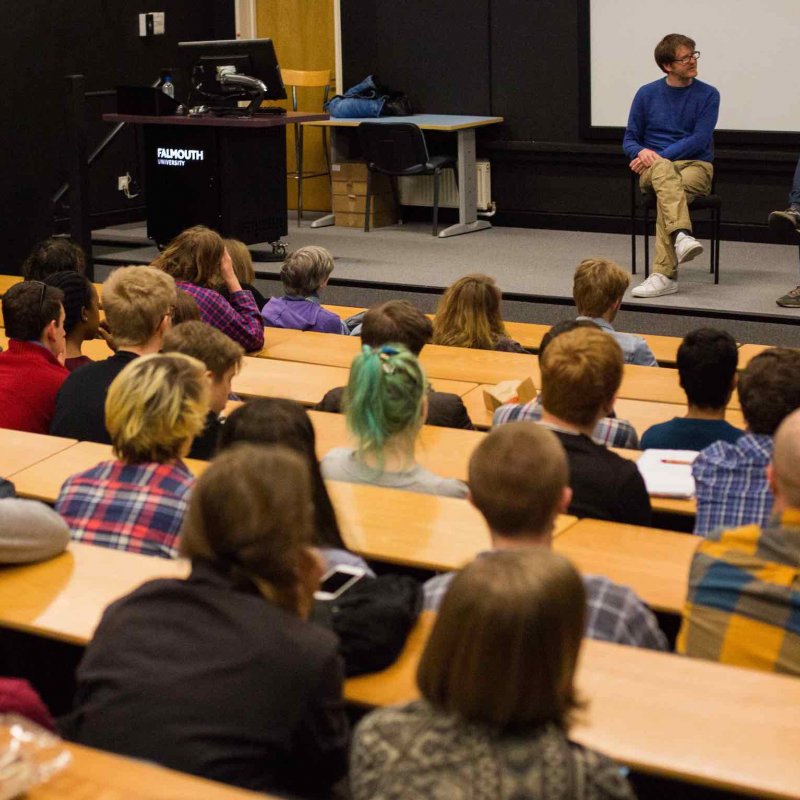 guest lecturer John Maclean on a stage with Film students sitting in an auditorium