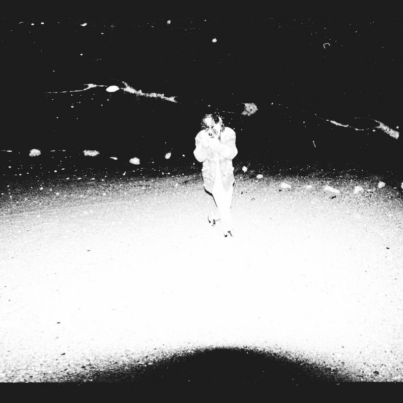 Grainy high contrast image of figure walking.