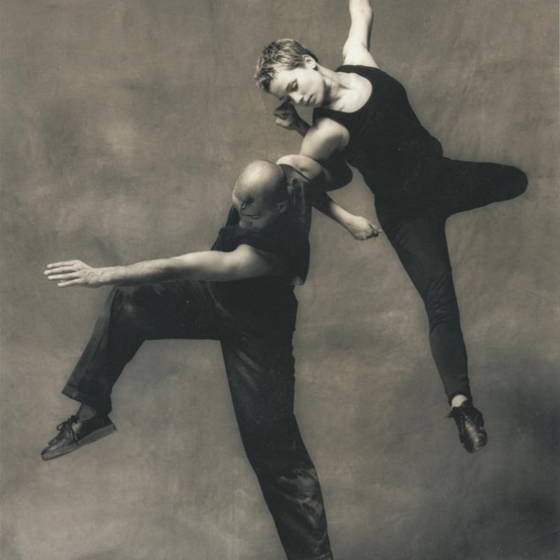 Dancers with arms linked mid air