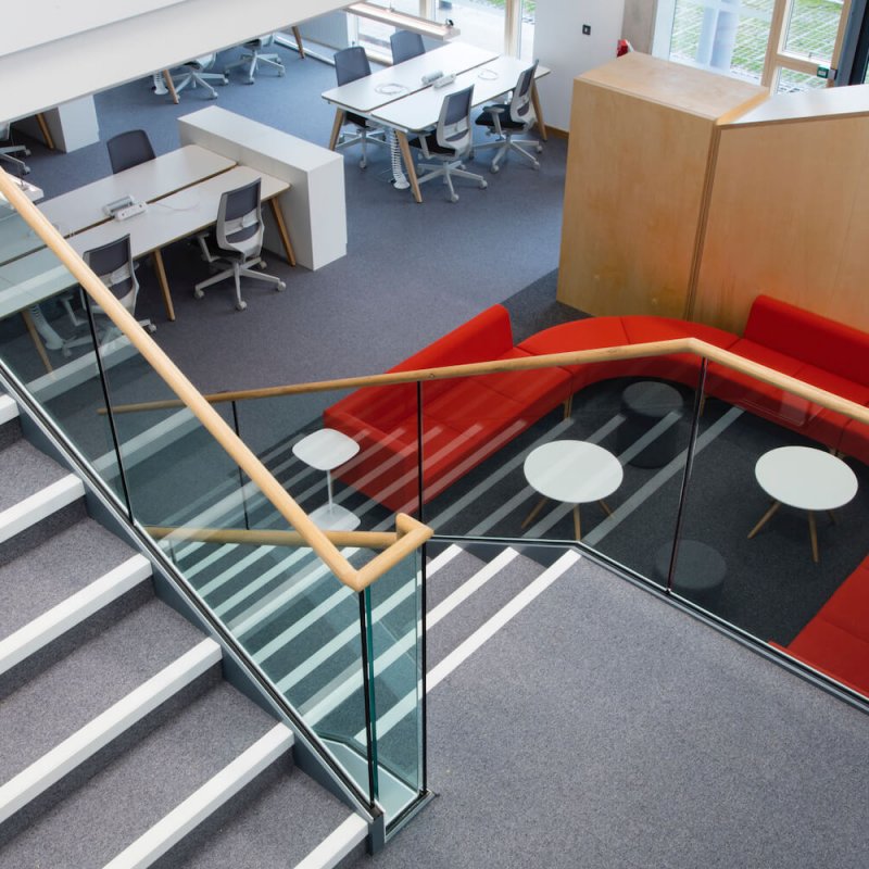 Looking down the staircase at Launchpad with a red sofa and desks