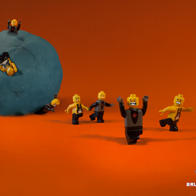 Lego figures being squashed by a ball of play-doh
