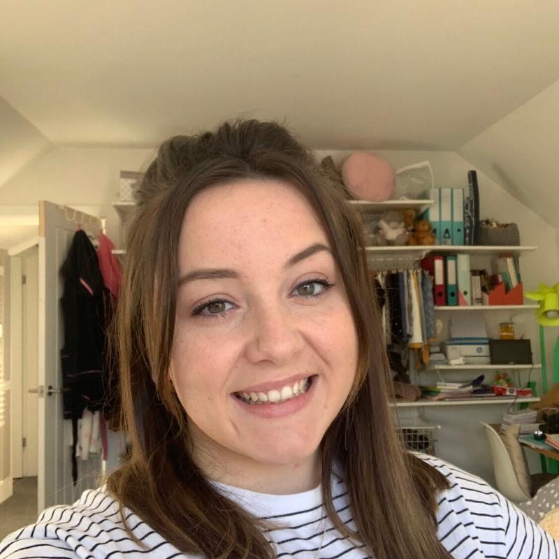 Falmouth University student smiling, wearing a striped top