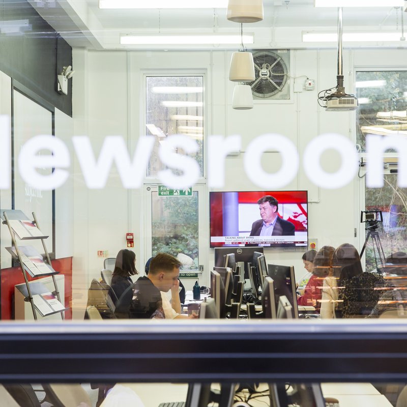View through window into the newsroom.