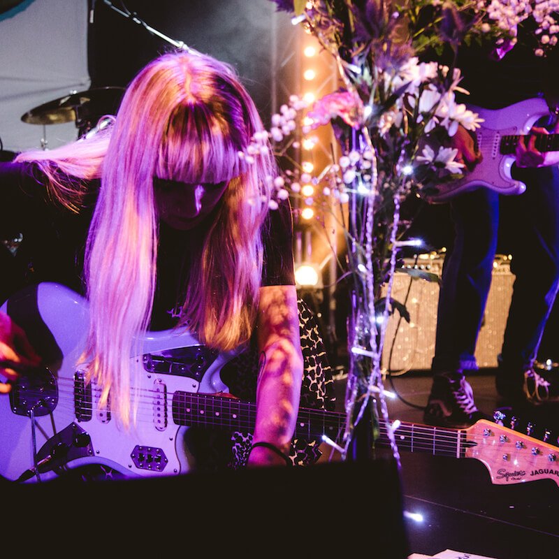 Girl with blonde hair, playing electric guitar