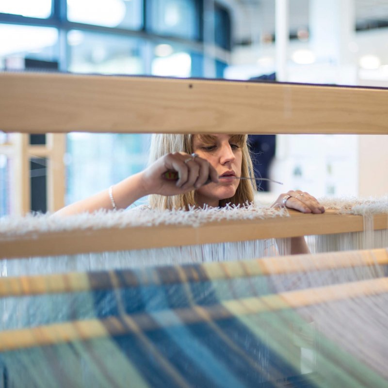 Student working on loom.